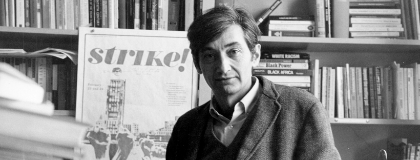 Howard Zinn in his office in front of a historical poster that reads "Strike"
